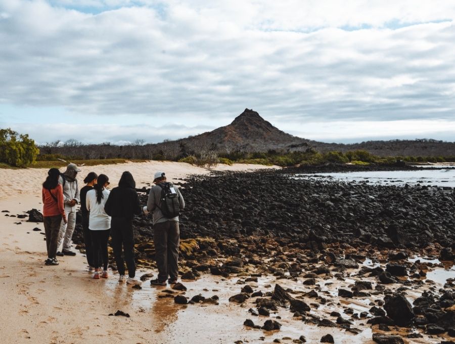 people walking through galapagos volcanic landscape